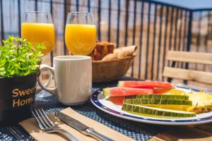 a table with a plate of food and two glasses of orange juice at Hotel Don Ignacio in San José