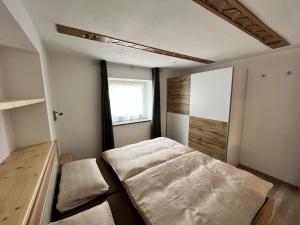 een kleine slaapkamer met een bed en een raam bij Ciasa Andy in Badia