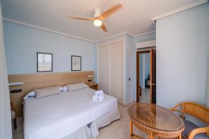 a bedroom with a white bed and a table at Hotel Don Ignacio in San José
