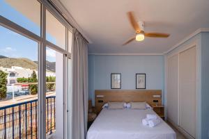 a bedroom with a bed and a large window at Hotel Don Ignacio in San José