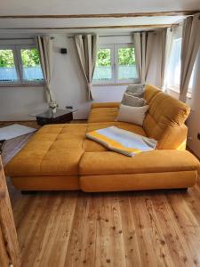 a large brown couch in a room with wooden floors at FEWO Peter und Britta 