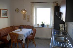 eine Küche mit einem Tisch mit Stühlen und einem Fenster in der Unterkunft Haus am Haff in Karnin