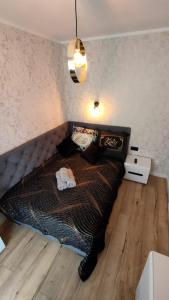 a bedroom with a large bed with a wooden floor at Haven Apart Karpacz in Karpacz