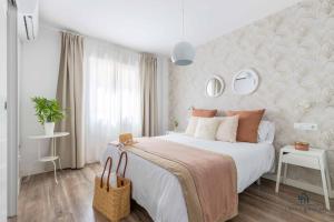 a bedroom with a large white bed and a wall at Living4Malaga Sea Breeze Apartment in Málaga