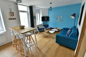 salon z niebieską kanapą i stołem w obiekcie Le 46 - T2 rénové, confortable proche centre-ville w mieście Montluçon