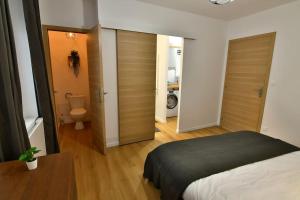 a bedroom with a bed and a bathroom with a toilet at Le 46 - T2 rénové, confortable proche centre-ville in Montluçon