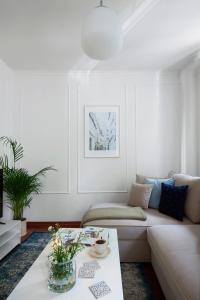 a living room with a white couch and a table at Elite Apartments Hamptons Old Town in Gdańsk