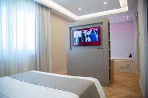 een slaapkamer met een bed en een tv aan de muur bij Hotel Ristorante Aeclanum in Mirabella Eclano