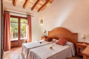 a bedroom with a bed and a large window at Finca Es Turo in Santanyi