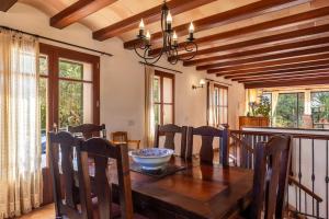 a dining room with a wooden table and chairs at Finca Es Turo in Santanyi