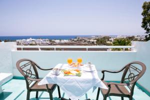 a table with two chairs and two glasses of orange juice at Apartamentos LIVVO Morromar in Puerto del Carmen