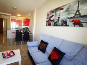 a living room with a blue couch and a kitchen at Puesta de Sol Rentals 3AJ in Playa de San Juan