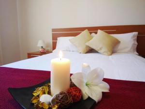 a candle on a tray with flowers on a bed at Puesta de Sol Rentals 3AJ in Playa de San Juan