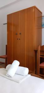a wooden cabinet with two white towels on a bed at FAROS in Agios Nikolaos