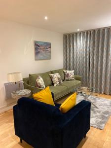 a living room with a green couch and yellow pillows at Fabulous 2 bed apartment in Vauxhall in London