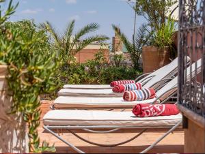 una fila de tumbonas sentadas en un patio en Riad Eloise, en Marrakech