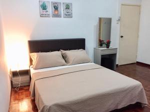 a bedroom with a large bed with white sheets at AiMAS Homestay Senawang Muslim in Seremban