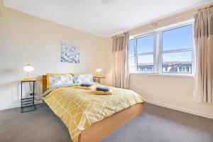 a bedroom with a bed and a large window at Bannermill Place Apartments - Grampian Lettings Ltd in Aberdeen