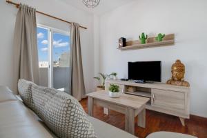 ein Wohnzimmer mit einem Sofa und einem TV in der Unterkunft Casa Jenny in Arrecife
