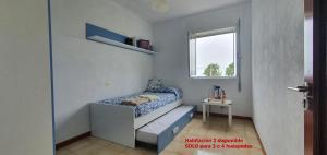 a small bedroom with a bed and a window at Carnota PLAYA a 100 metros in Carnota