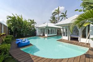 una piscina con terraza de madera y una casa en Villa Laksmana Hideaway 2 - Surrounded by water- 2bd villa with fantastic pool!, en Seminyak