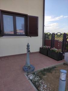 a house with two windows and a fire hydrant on a patio at Casa Vacanze Magnolia in Scanzano