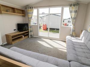 a living room with a couch and a tv at C22 Par Sands in Par