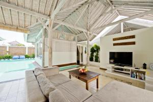 a living room with a couch and a tv at Villa Laksmana Hideaway 2 - Surrounded by water- 2bd villa with fantastic pool! in Seminyak