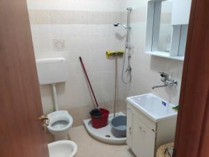 a bathroom with a toilet and a sink and a mop at Casa Vacanze Magnolia in Scanzano