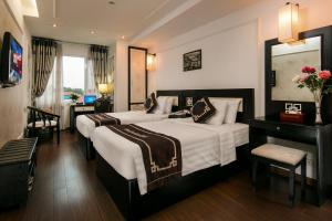 ハノイにあるハノイ エモーション ホテルのベッド2台とデスクが備わるホテルルームです。