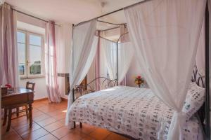 1 dormitorio con cama con dosel, mesa y ventana en LOCANDA FAZIO en Roma