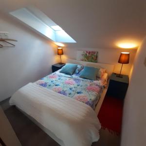 a small bedroom with a bed with blue pillows at Orange Cube Apartment - Self check in - Free parking in Rijeka +38 photos