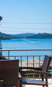 a balcony with two chairs and a view of the water at Nikolaos Apartment in Nydri