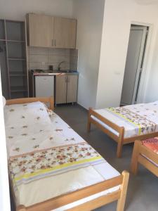 una piccola camera con due letti e una cucina di Apartments 4 u a Donji Štoj