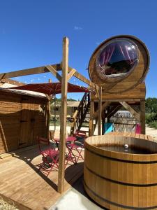 a wooden deck with a wooden barrel and a circular at Hébergement Insolite avec SPA - Foudrenlair in Bize-Minervois