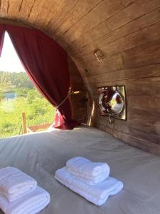 two folded towels sitting on a bed with a mirror at Hébergement Insolite avec SPA - Foudrenlair in Bize-Minervois