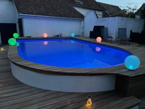 een groot blauw zwembad op een terras met verlichting bij La Parenthèse in Richebourg