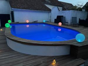 une grande piscine bleue sur une terrasse éclairée dans l'établissement La Parenthèse, à Richebourg