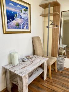 a wooden table and chair in a room with a painting at Apartments Adaleta in Dubrovnik