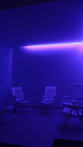 a row of chairs in a room with a blue light at Hotel Monte Lírio in Espinho