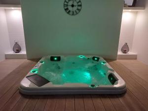 a hot tub in a room with a clock on the wall at Hotel Monte Lírio in Espinho