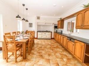 a kitchen with a wooden table and wooden cabinets at Bryn Meilw in Holyhead
