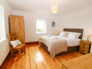 a bedroom with a bed and a wooden floor at Bryn Meilw in Holyhead