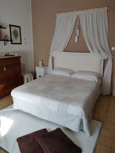 una camera con 2 letti bianchi e un comò di B&B Il Giardino di Sophie a Villafranca di Forlì
