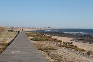 a boardwalk leading to a beach with animals on it at Hotel Monte Lírio in Espinho