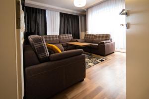 CedarTREE Prishtina في بريشتيني: غرفة معيشة مع كنبتين وأريكة