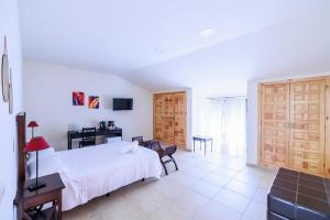 ein Schlafzimmer mit einem weißen Bett und einem Schreibtisch sowie ein Zimmer in der Unterkunft La Posada de la Gula in Jarandilla de la Vera