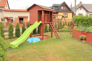 un parque infantil con un tobogán en un patio en Apartman ViVi Pribylina en Liptovský Mikuláš