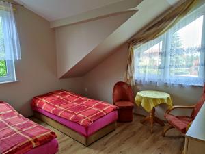 Zimmer mit 2 Betten, einem Tisch und einem Fenster in der Unterkunft Domki dla rodzin z dziećmi domkicetniewoPL in Władysławowo