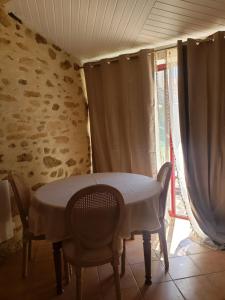 comedor con mesa, sillas y ventana en Studio Léonie, le cottage de l'étang, en Le Tablier
